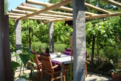 Pergola aus Naturstein mit Kastanienholz